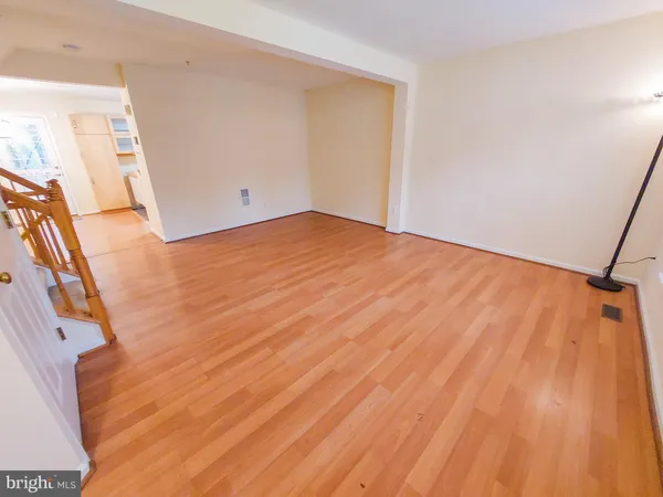 a view of a room with wooden floor and white walls