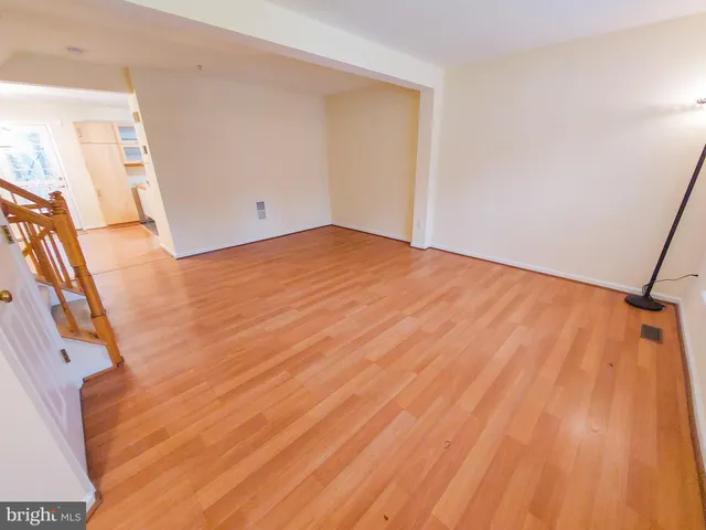 a view of a room with wooden floor and white walls