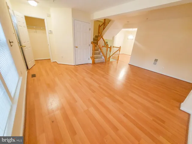 a view of an empty room with wooden floor