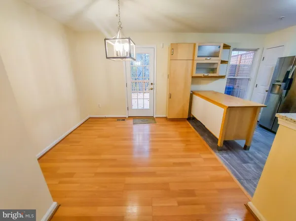 a view of a kitchen with fridge and wooden floor