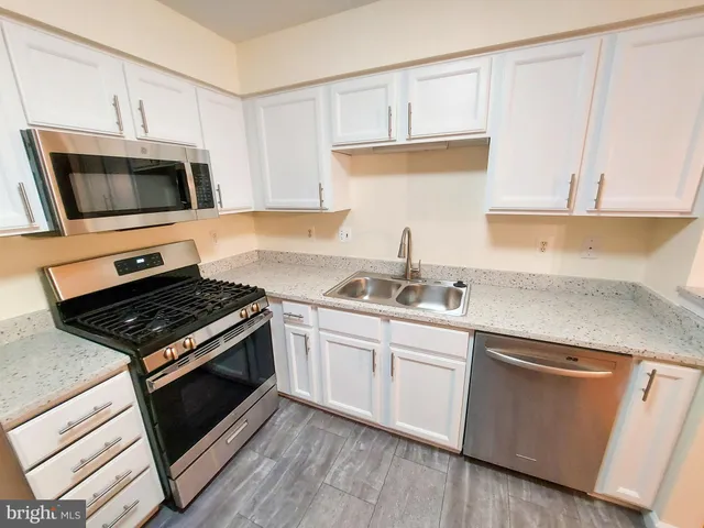 a kitchen with cabinets appliances and a sink
