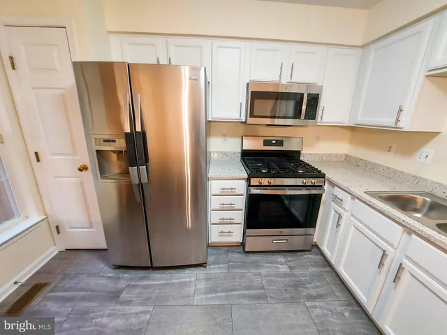 a kitchen with granite countertop a refrigerator and a stove