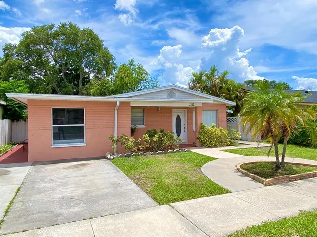 a front view of a house with a yard and potted plants