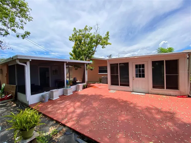 a front view of a house with a large window and potted plants