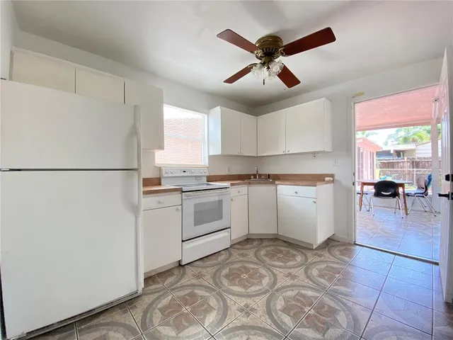 a kitchen with a refrigerator and white cabinets