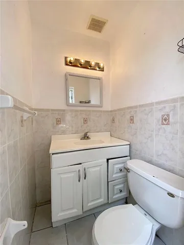 a bathroom with a granite countertop toilet sink and mirror