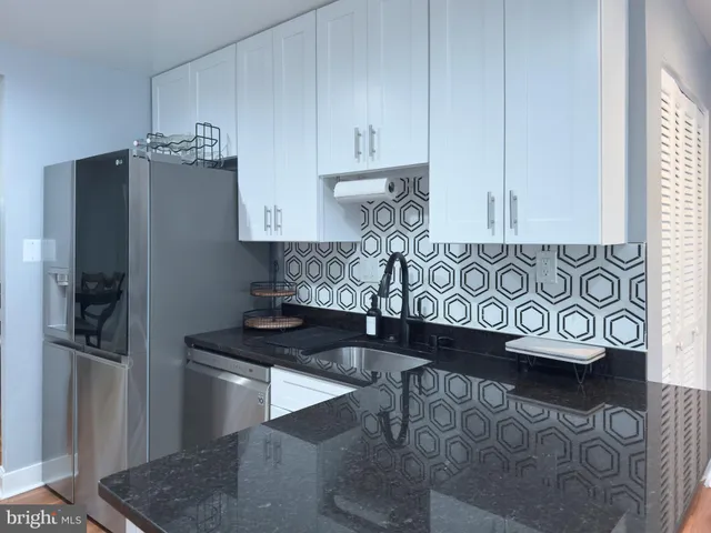 a kitchen with stainless steel appliances granite countertop a refrigerator and a stove