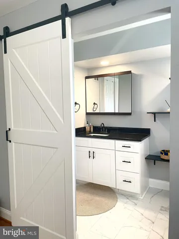 a kitchen with a refrigerator and white cabinets