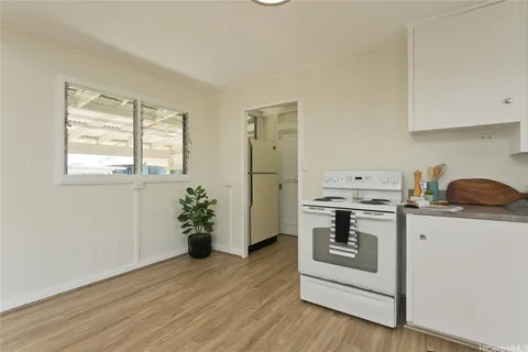 a kitchen with stainless steel appliances white cabinets and wooden floor
