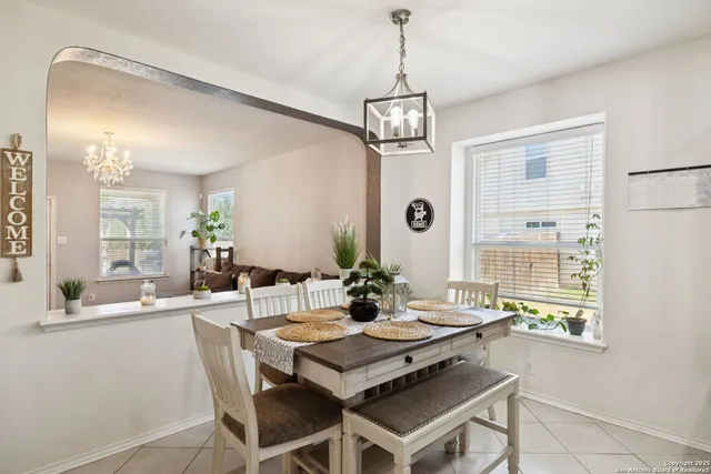 a kitchen with a dining table chairs microwave and refrigerator
