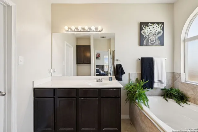 a bathroom with a double vanity sink and a large mirror