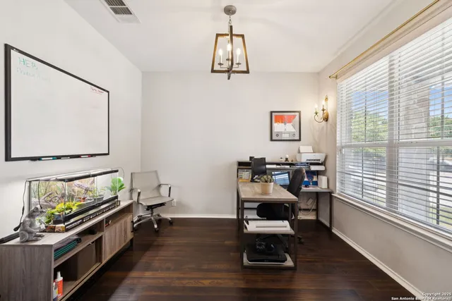 a view of a workspace with furniture and a window