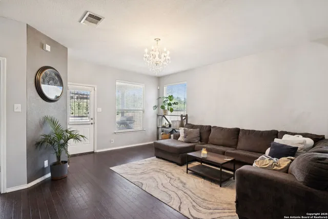 a living room with furniture a chandelier and a window