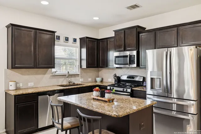 a kitchen with stainless steel appliances granite countertop a refrigerator stove microwave and sink