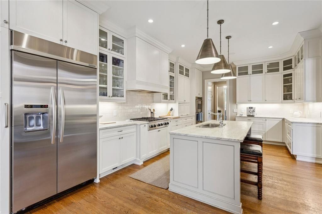 3005 Ranch Road Southeast Atlanta, GA 30339 - Photo 22 of 57 a kitchen with stainless steel appliances kitchen island granite countertop a refrigerator a sink dishwasher a stove and white cabinets with wooden floor