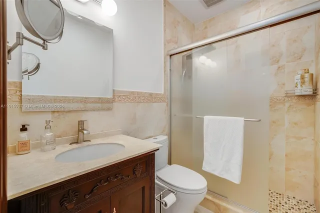 a bathroom with a granite countertop sink toilet and shower