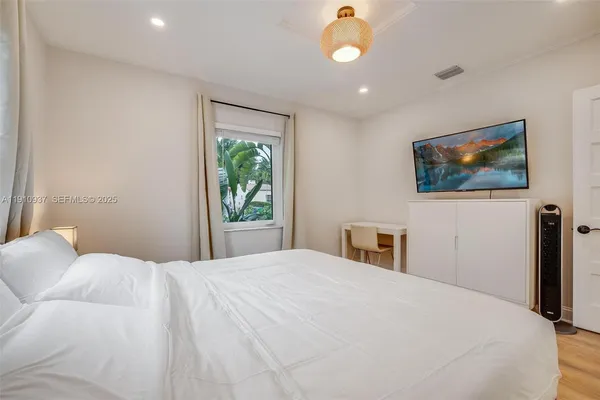 a bedroom with a large bed and a window