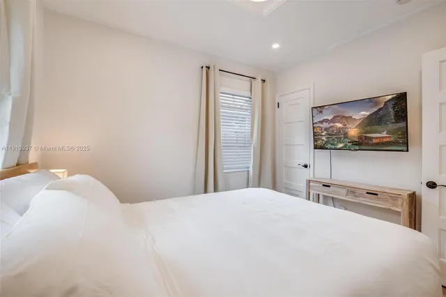 a bedroom with a bed and a flat screen tv