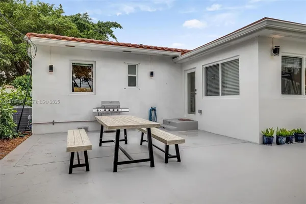 a backyard of a house with table and chairs