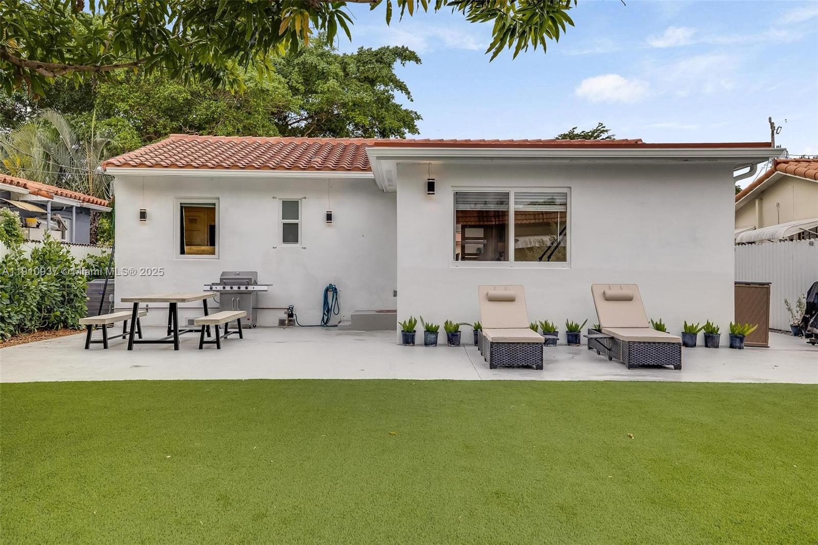 2969 Southwest 20th Street Miami, FL 33145 - Photo 26 of 28 a view of a patio with table and chairs potted plants with wooden fence