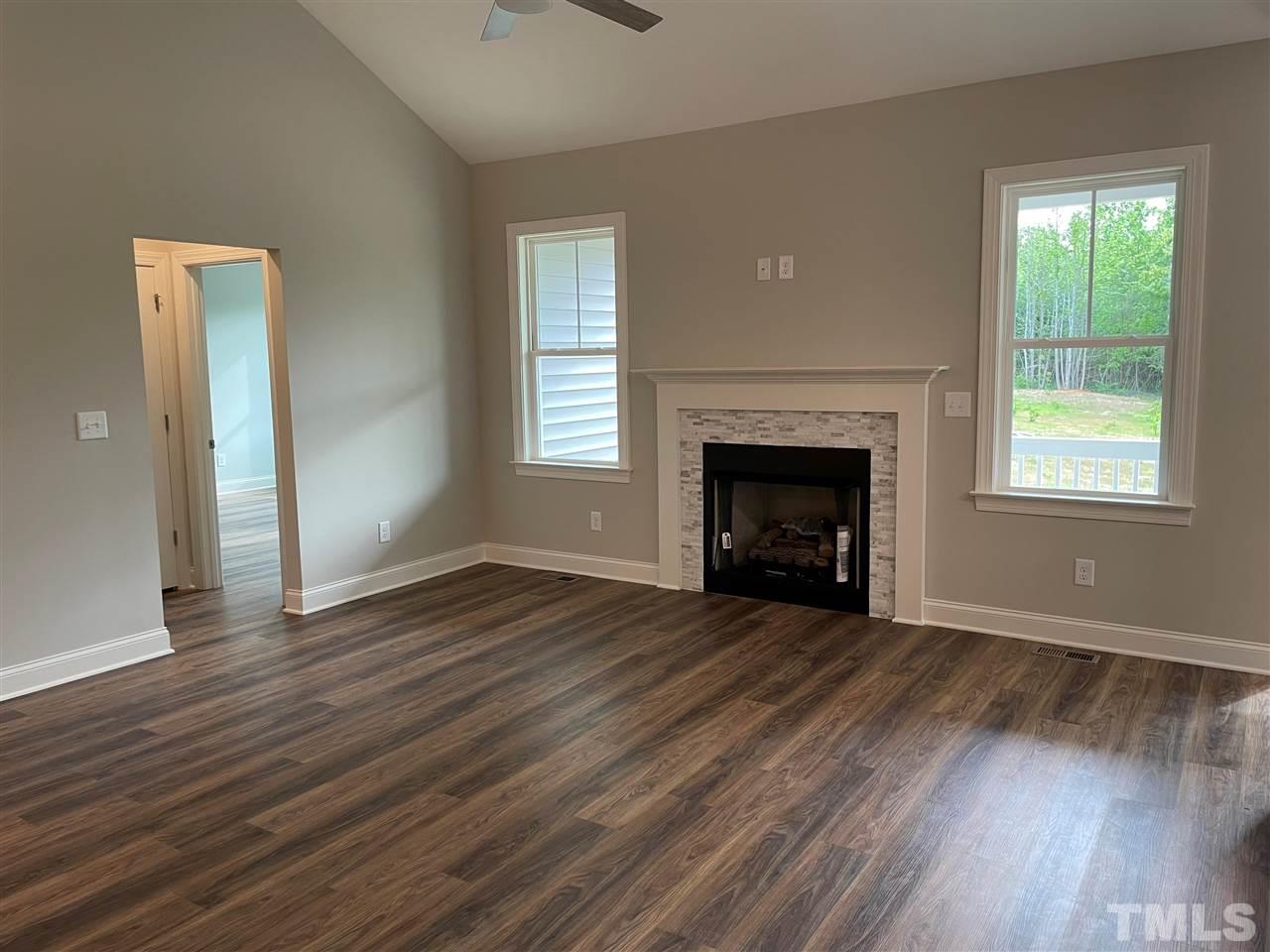 1820 Bryantown Road Spring Hope, NC 27882 - Photo 6 of 23 a view of an empty room with wooden floor fireplace and a window