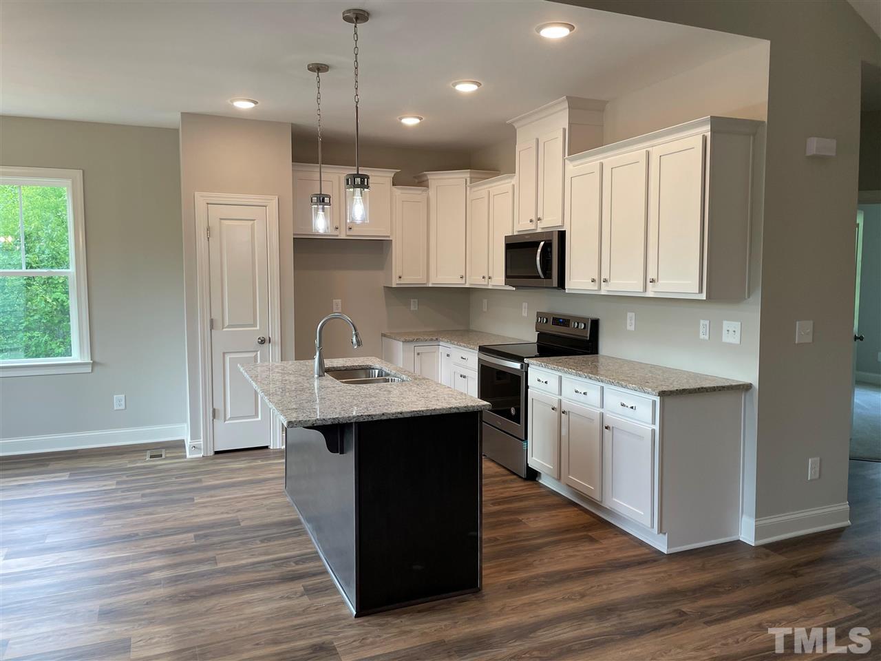 1820 Bryantown Road Spring Hope, NC 27882 - Photo 7 of 23 a kitchen with kitchen island granite countertop a sink and wooden floor