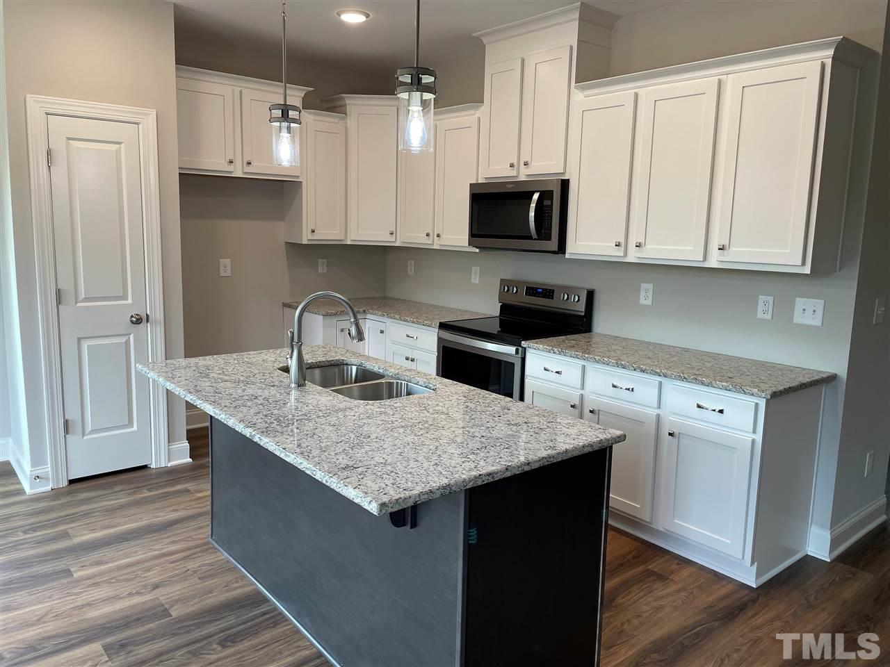 1820 Bryantown Road Spring Hope, NC 27882 - Photo 8 of 23 a kitchen with stainless steel appliances granite countertop a sink stove and microwave