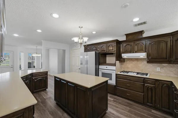 an empty room with wooden floor and ceiling fan