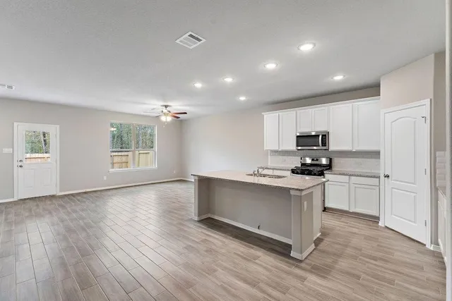 a kitchen with cabinets and wooden floor