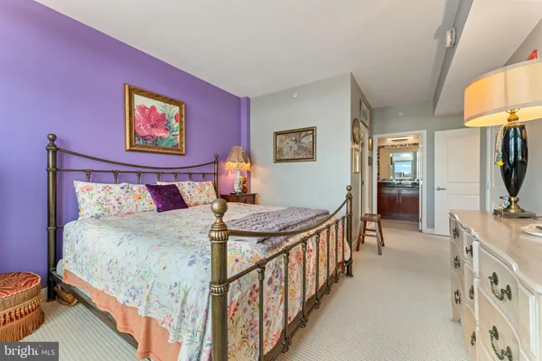 a bedroom with bed and a flat tv screen on dresser