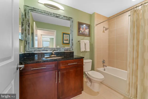 a bathroom with a toilet a sink a mirror a bathtub and shower