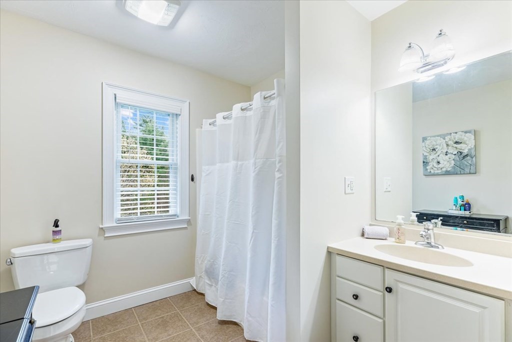 176 Marion Road Middleboro, MA 02346 - Photo 17 of 41 a bathroom with a toilet a sink a mirror a window and vanity