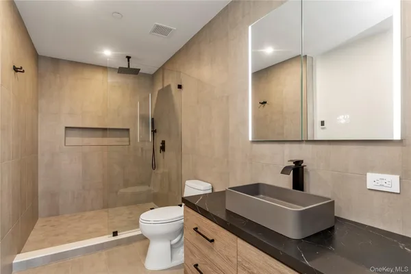 a bathroom with a sink a toilet and shower