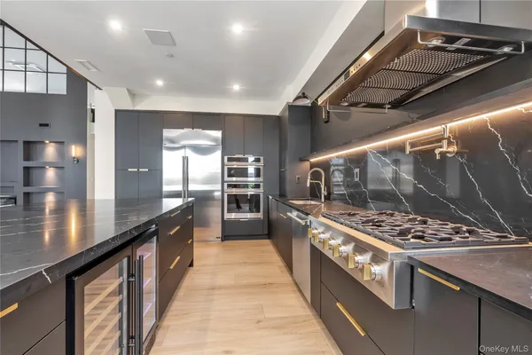 a large kitchen with stainless steel appliances kitchen island a large stove a sink and cabinets