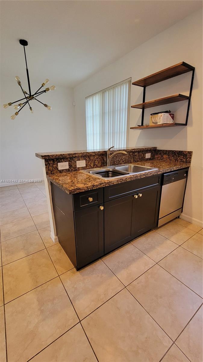 12600 Southwest 50th Court, Unit 437 Miramar, FL 33027 - Photo 7 of 24 a kitchen with stainless steel appliances granite countertop a stove a sink and a refrigerator