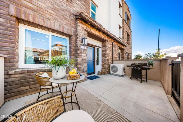 a view of a patio with couches table and chairs and potted plants