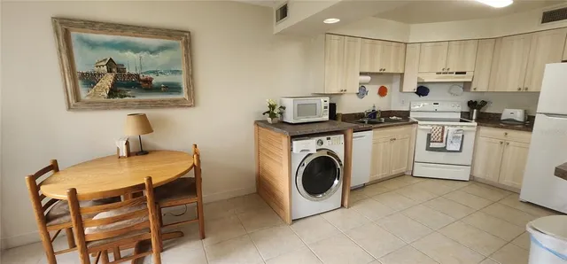 a kitchen with a stove a sink a refrigerator and a stove top oven