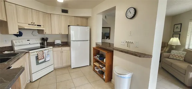 a kitchen with a refrigerator sink and white cabinets
