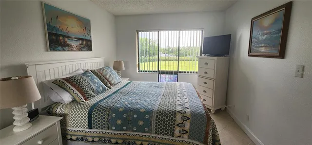 a bedroom with a bed and a painting on the wall