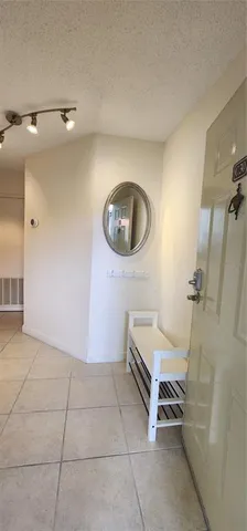 a view of a livingroom with a chair and a potted plant on the wall