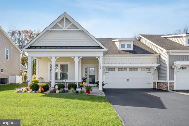 a front view of a house with a garden and plants