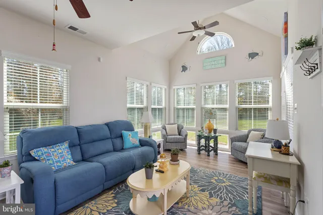a living room with furniture a large window and a chandelier