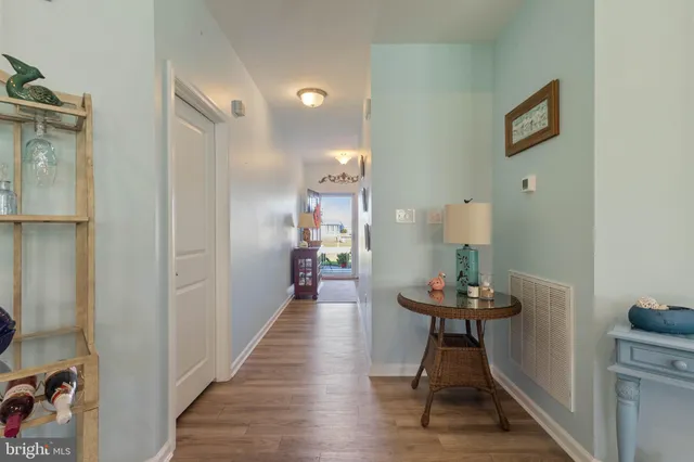 a view of a hallway with furniture and wooden floor