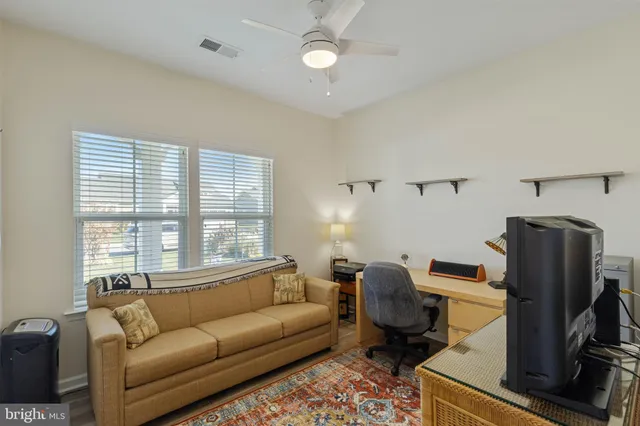 a living room with furniture a flat screen tv and a window