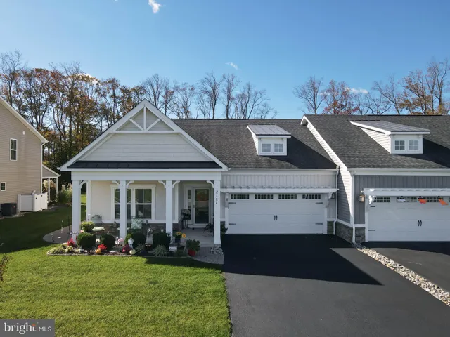 a view of a white house with a big yard and potted plants