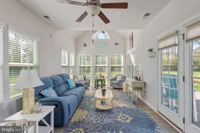 a living room with furniture chandelier and a large window