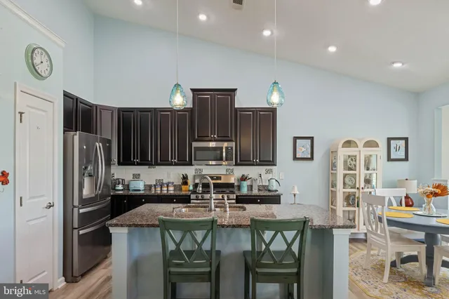a kitchen with stainless steel appliances granite countertop a refrigerator and a stove top oven