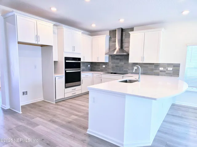 a view of kitchen with kitchen island wooden floor and center island