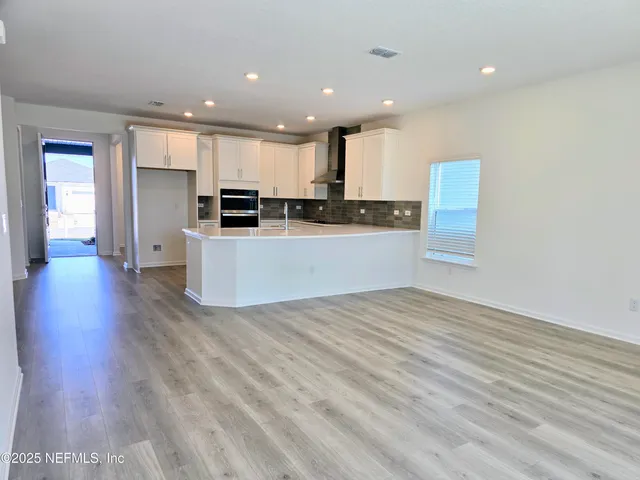 a large kitchen with kitchen island a sink stainless steel appliances and cabinets