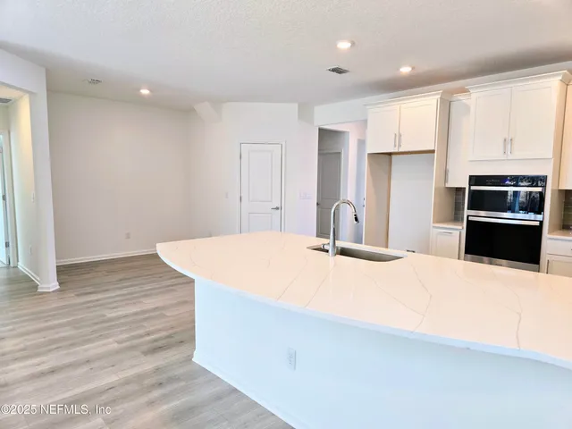 a kitchen with granite countertop a sink a stove and cabinets